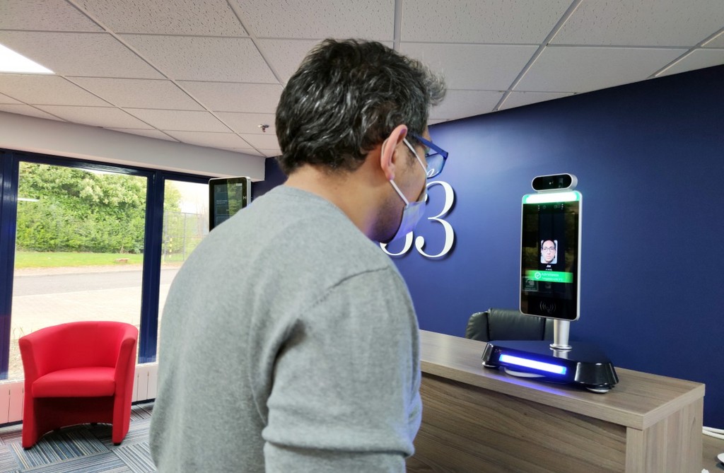 Temperature Kiosk Being Used By Man At Reception